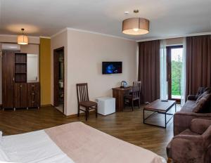 a living room with a bed and a couch and a table at Resolute Shekvetili Hotel in Shekhvetili