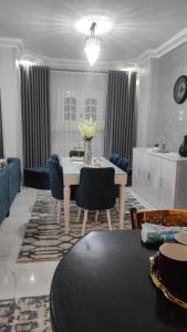 a living room with a table and blue chairs at Heaven 2 in Mīt Abū Shaykhah