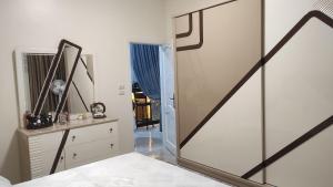 a bedroom with a mirror and a dresser and a door at Heaven 2 in Mīt Abū Shaykhah