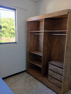 a wooden book shelf in a room with a window at Quartos Residencial Arcos in Arcos