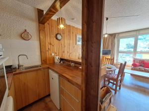 a kitchen with a wooden counter top and a table at Studio 4 pers, centre station Les Deux Alpes, animaux admis - FR-1-516-75 in Les Deux Alpes +3 photos