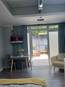 a living room with a table and a couch at The Welcome Haven - Cozy Studio with Patio & Free Parking in Chislehurst
