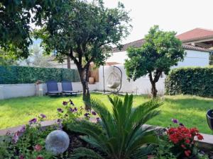 a garden with two chairs and flowers in a yard at Pelion Malaki- Casa Verde in Malaki
