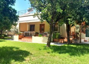a house with a green yard with a tree at Pelion Malaki- Casa Verde in Malaki