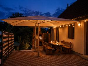 a patio with an umbrella and a table and chairs at Coco & Simi Lakeside Nest in Cinciş
