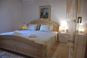 a bedroom with a large wooden bed with towels on it at Lazatka in Samothraki