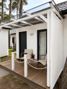 a wooden deck with a pergola on a house at Szarotka Łeba - nowe domki blisko plaży in Łeba