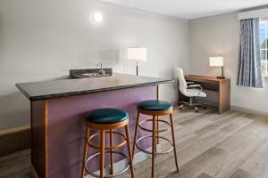 a hotel room with two bar stools and a sink at Days Inn by Wyndham Mt. Vernon in Mount Vernon