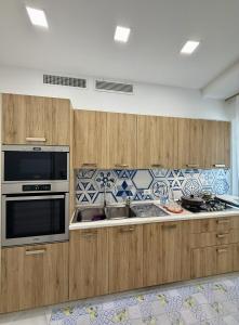 a kitchen with wooden cabinets and a stove top oven at Capri House - camera Luna Caprese in Minori