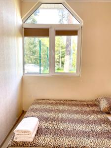 ein Bett in einem Zimmer mit Fenster in der Unterkunft Hotel K.V.N. in Ragaciems + 13 Fotos