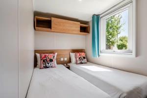 a small bedroom with two beds and a window at Le petit paradis du golfe in Gassin
