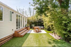 a backyard with a wooden bench and a table at Le petit paradis du golfe in Gassin
