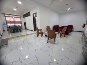 a living room with a couch and chairs on a marble floor at Villa at 37 in Badulla