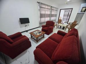 a living room with two red couches and a table at Villa at 37 in Badulla