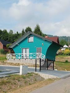 a blue house with a black roof on the side of a road at Domki Ale Góry Beskid Żywiecki Korbielów in Korbielów