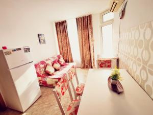 a living room with a table and a refrigerator at Apartment Blue Komfort in Sunny Beach