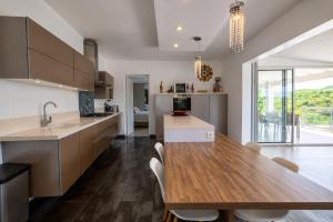 a kitchen with a wooden table and a dining room at Villa Ellia - Terres Basses in Les Terres Basses