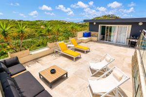a patio with a couch and chairs and a table at Villa Ellia - Terres Basses in Les Terres Basses