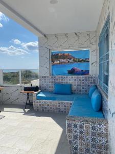 a room with a couch and a tv on a wall at Ain grenz in Kelibia