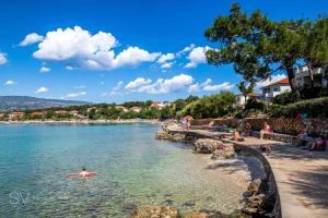 a person swimming in the water at a beach at Apartment Magnolia in Šilo