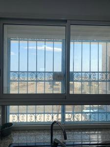 a kitchen window with a view of the beach at Ain grenz in Kelibia