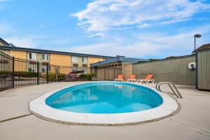 a swimming pool in a yard with chairs and a fence at Days Inn by Wyndham Mt. Vernon in Mount Vernon