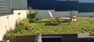 two chairs and a table in a yard at Chambres D'Hotes Chez Sylvie in Cancale