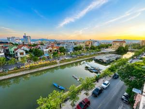 a city with a river and cars parked on the street at ĐAN MY Motel in Dong Hoi