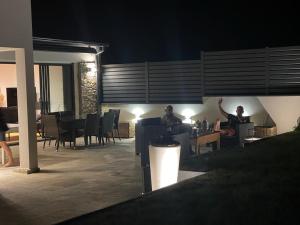 two people sitting at a table on a patio at night at Chambres D'Hotes Chez Sylvie in Cancale