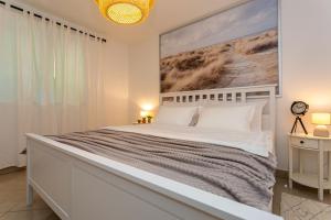 a bedroom with a large bed with a large painting on the wall at Apartment Magnolia in Šilo