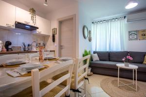 a kitchen and living room with a table and a couch at Apartment Magnolia in Šilo +22 photos
