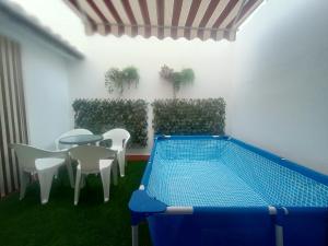 a patio with a table and chairs and a swimming pool at Casa Villa Duque in El Bosque