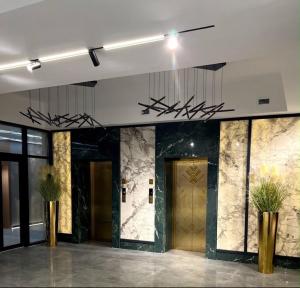 a lobby with a door and plants in a building at Raduga West Apart Hotel in Koshkolʼ