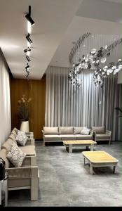 a living room with couches and tables in a room at Raduga West Apart Hotel in Koshkolʼ