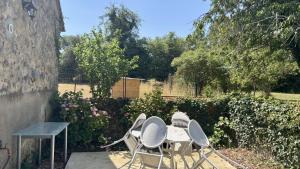 a group of chairs and a table in a garden at À la Pays Anes in Tannerre-en-Puisaye +10 photos