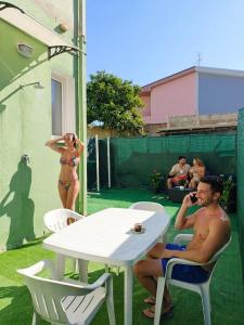 a man and a woman in bathing suits sitting at a table at In DhomeU Tua - Free Wifi & Private Garden in Selargius +19 photos