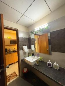 a bathroom with a sink and a mirror at Nest And Rest Stay in Greater Noida