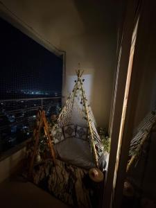 a bed in a room with a view of a city at Nest And Rest Stay in Greater Noida