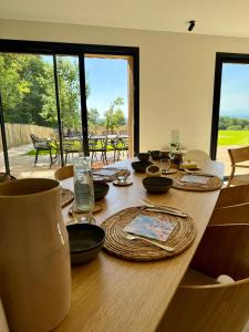 a wooden table with plates and glasses on top of it at GiteLaGrange in Lalanne-Arqué