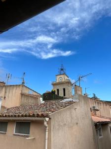 a building with a clock tower on top of it at Apparemment Cocooning Ceyreste in Ceyreste +2 photos