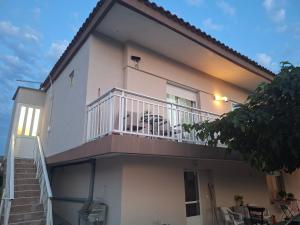 a white house with a balcony and stairs at Imeros Summer Home 3 in Ímeros +2 photos