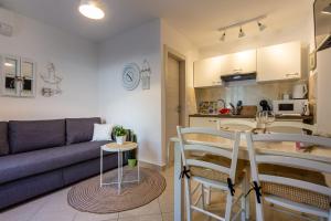 a living room with a couch and a table and chairs at Apartment Magnolia in Šilo