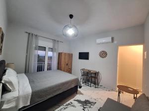 a bedroom with a bed and a table and a window at Imeros Summer Home 3 in Ímeros