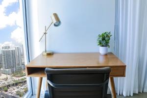 a desk with a lamp and a plant in front of a window at Modern Studio by Brickell & Beach in Miami +14 photos