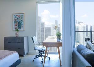 a bedroom with a desk and a bed and a window at Modern Studio by Brickell & Beach in Miami