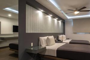 a bedroom with two beds and a ceiling fan at Hotel MX congreso CDMX, Trademark Collection by Wyndham in Mexico City