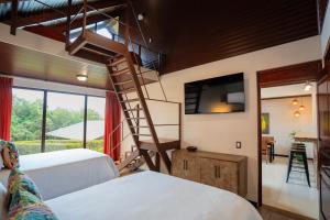 a bedroom with two beds and a spiral staircase at Green Forest Rustic Houses in Monteverde Costa Rica