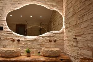 a stone bathroom with two sinks and a mirror at Pelagio Residence in Samothraki +78 photos
