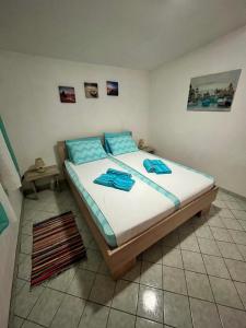 a bedroom with a bed with blue pillows on it at Vila Maša in Utjeha