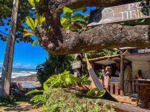 a restaurant on the beach next to the ocean at Pousada Tiririca Surf in Itacaré